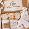 A gift box containing various items for a new mother, including a white cloth, a white eye mask, and a set of bath products.