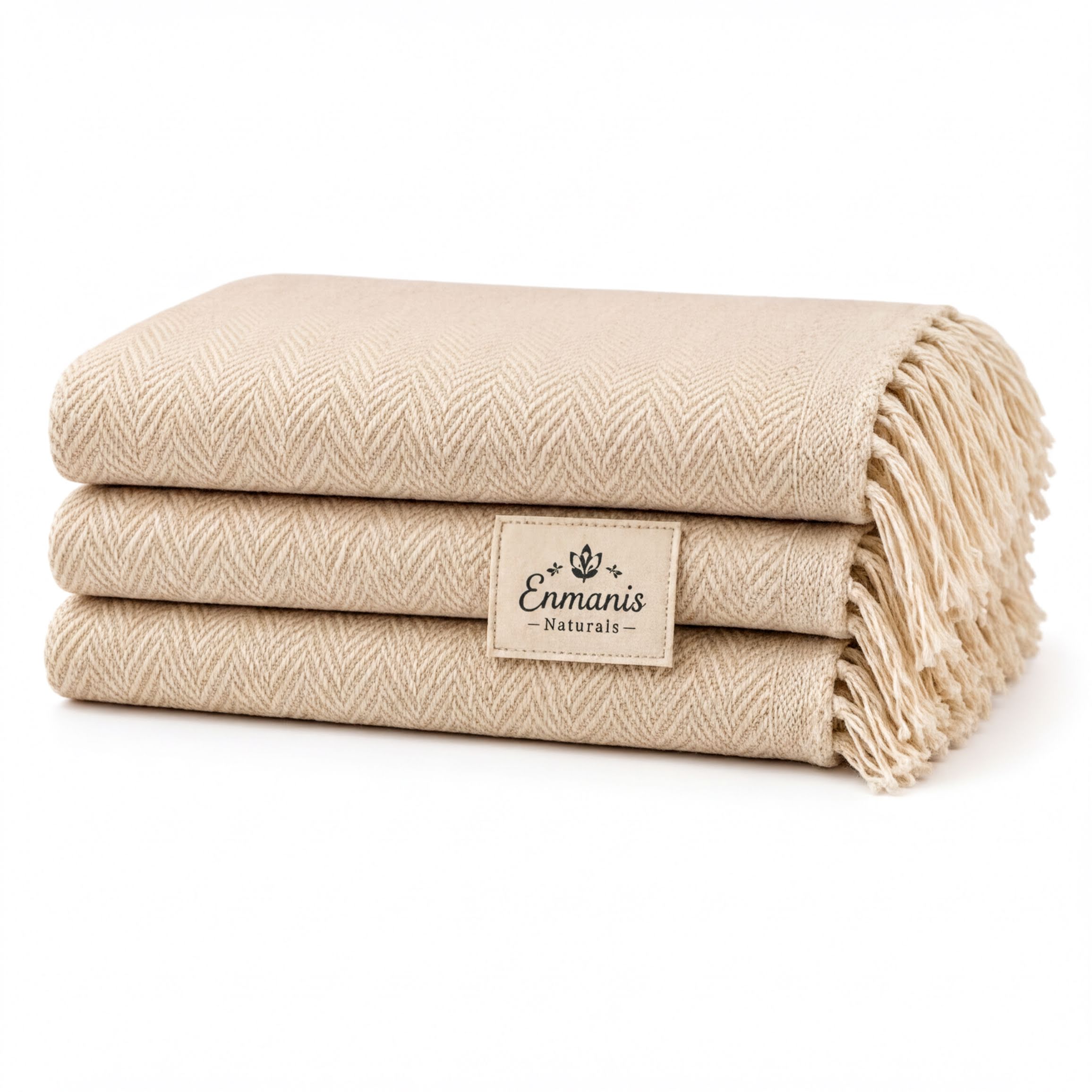 A stack of three beige towels with fringe, each labeled "Enmanis Naturals".
