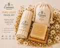 a set of natural beauty products from Enmanis Naturals, including a travel set, a travel bag, and a bar of soap, all surrounded by a floral arrangement.
